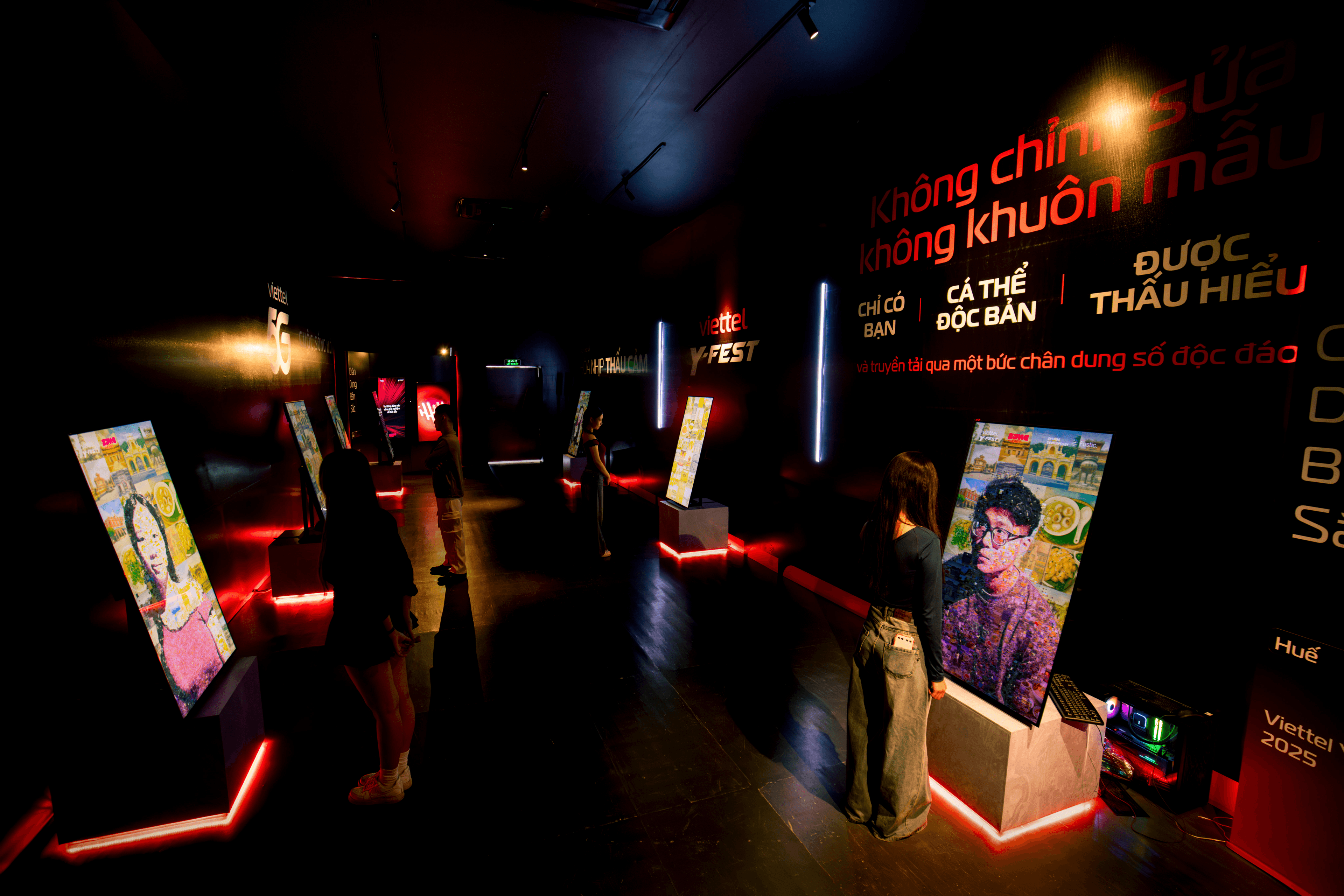Wide view of the installation gallery showing visitors standing before generative portrait display lined along the walls
