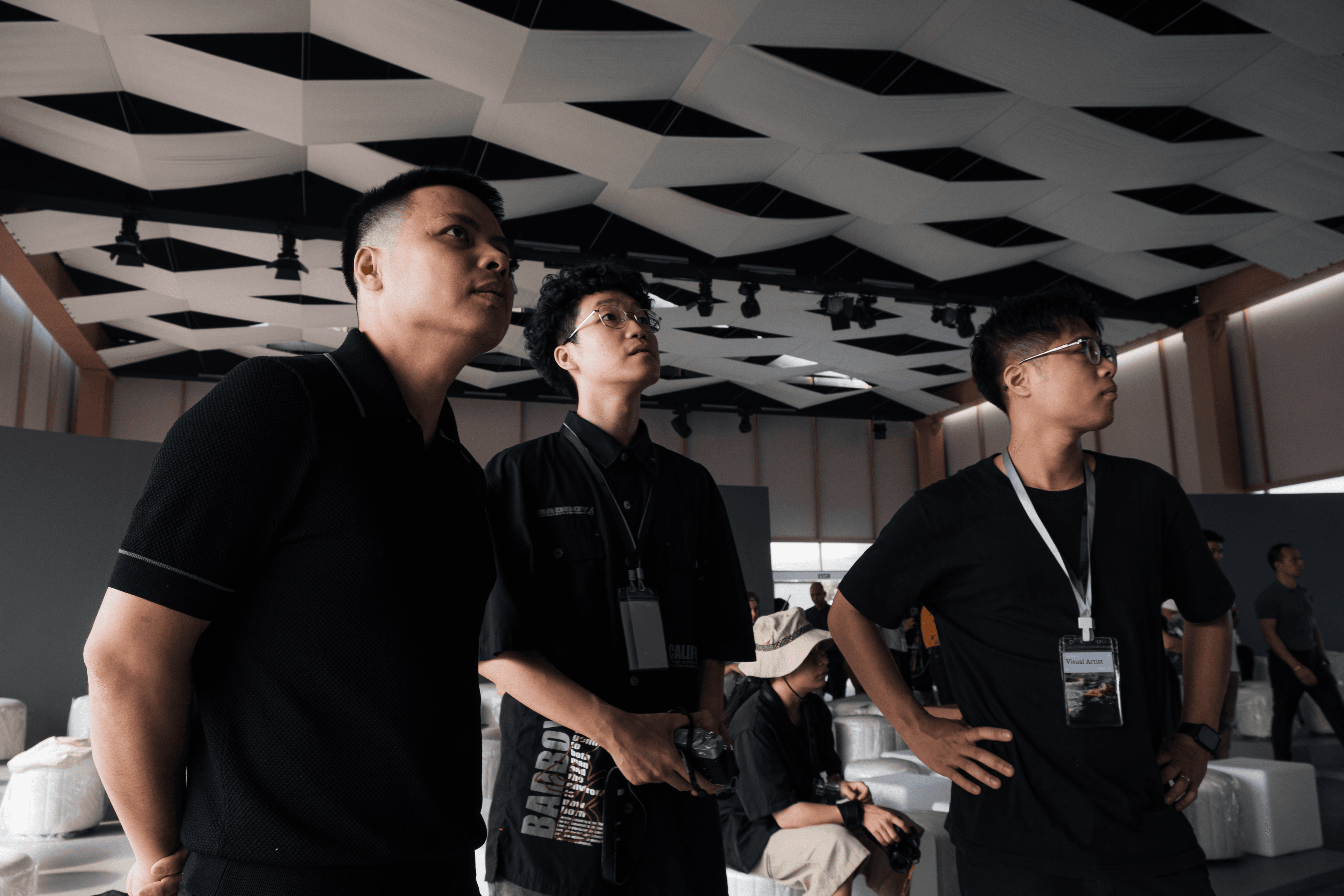 The creative team is looking upward attentively, likely observing the visual displays or stage performance.