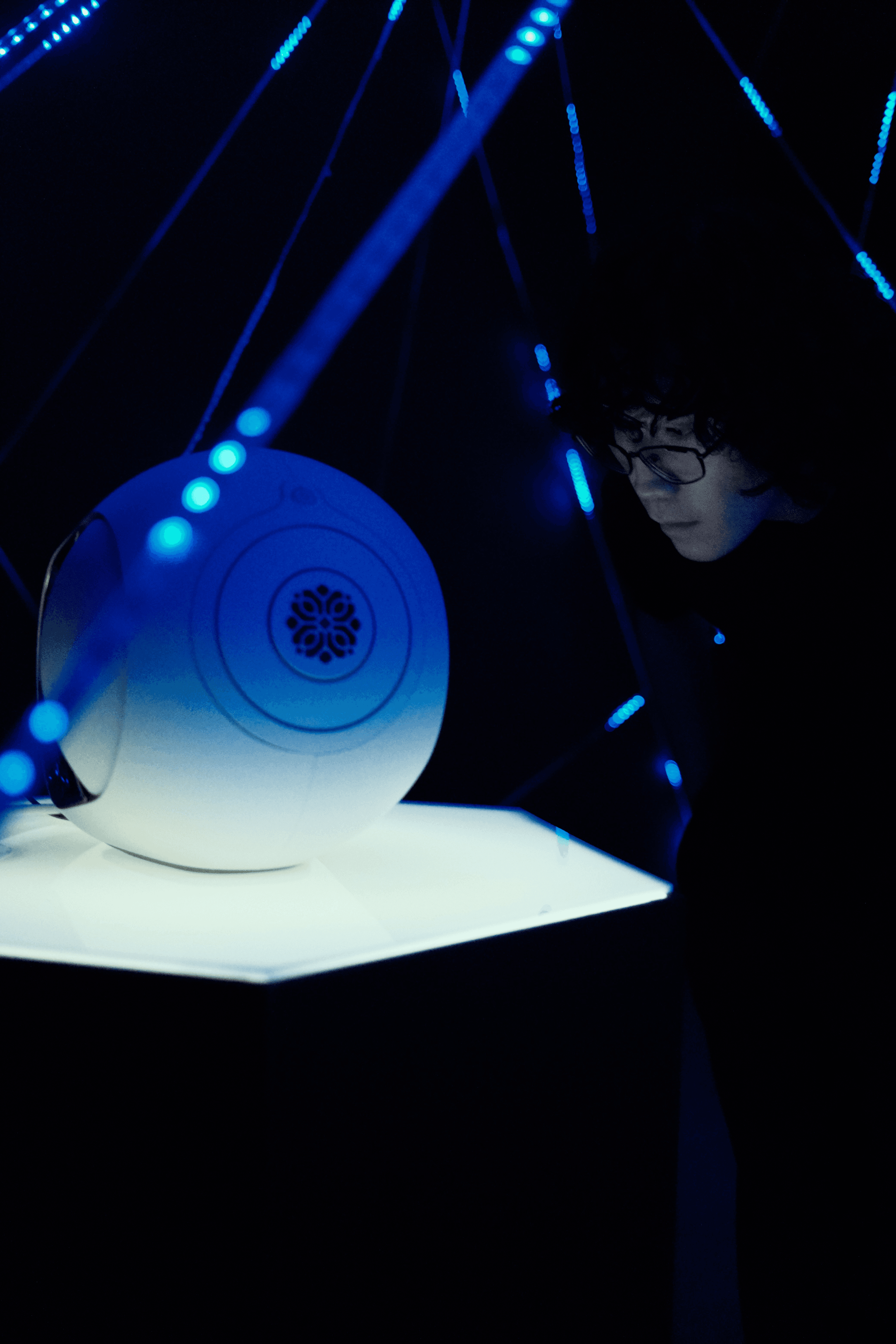 A man leans in to closely examine the speaker inside the installation
