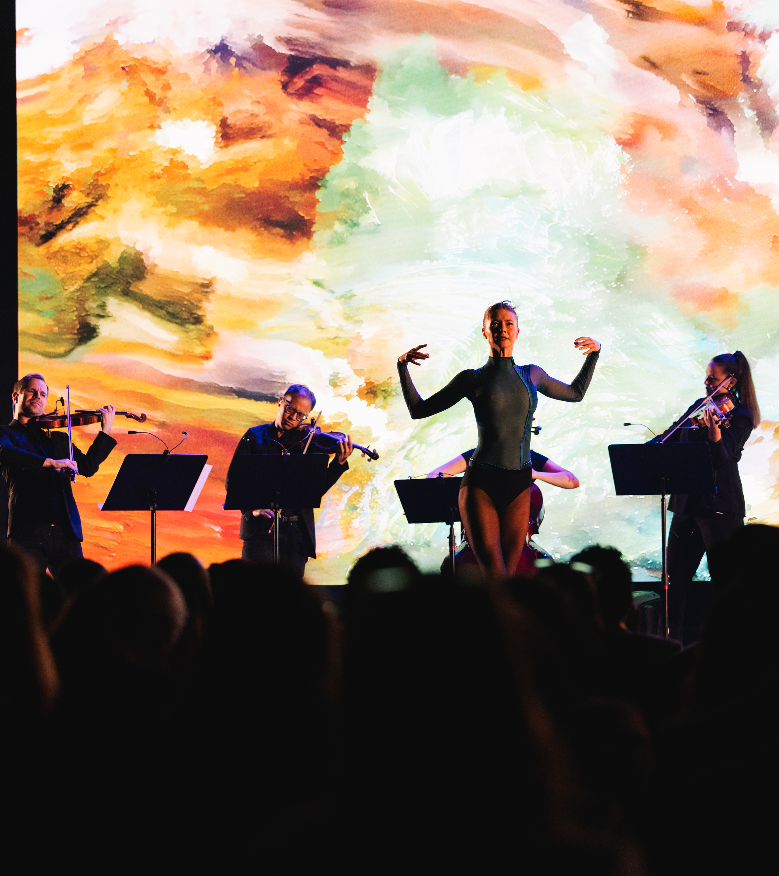A dancer performs at centre stage during the AI For Good Summit 2025, surrounded by a string quintet.