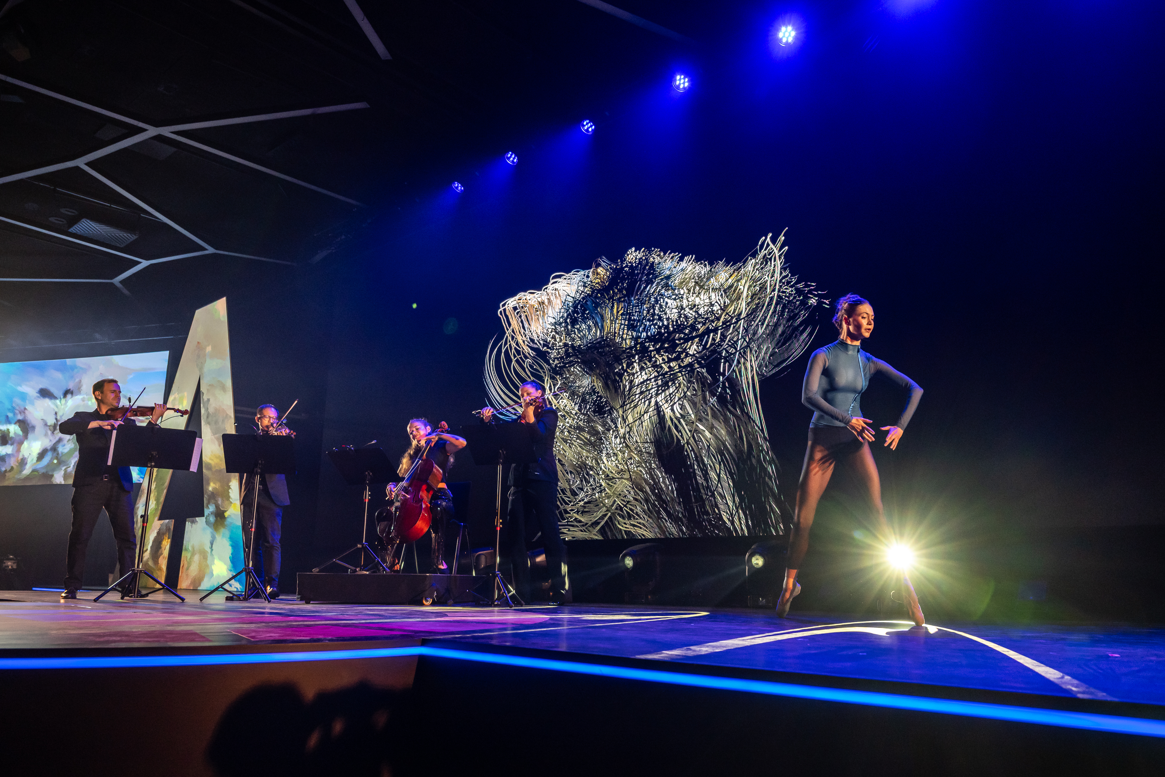 Installation view of the live performance stage at the AI4Good Summit 2025. Wide shot from the front-left of the stage.