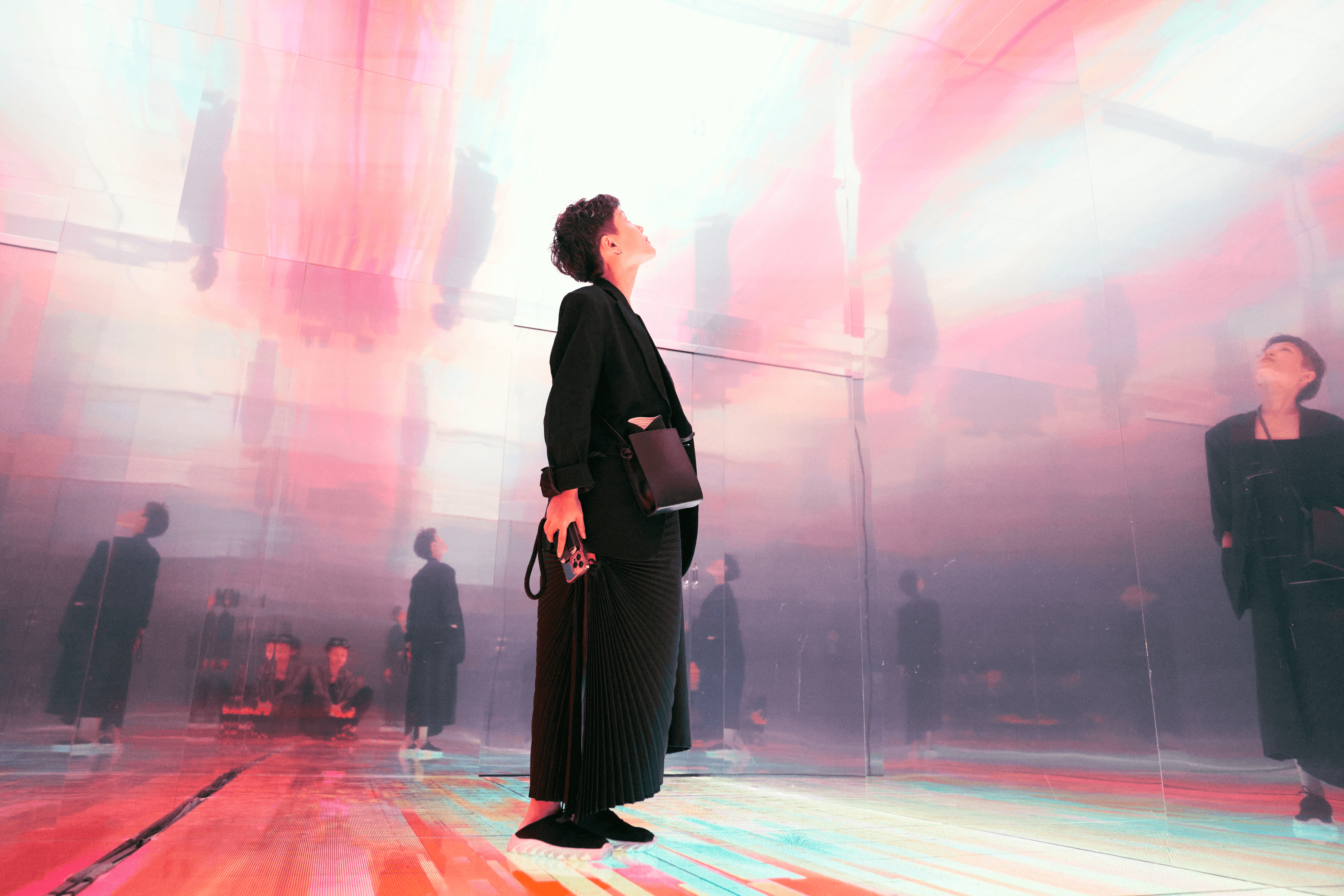 A visitor looking up inside a immersive mirrored room filled at the Đủ exhibition