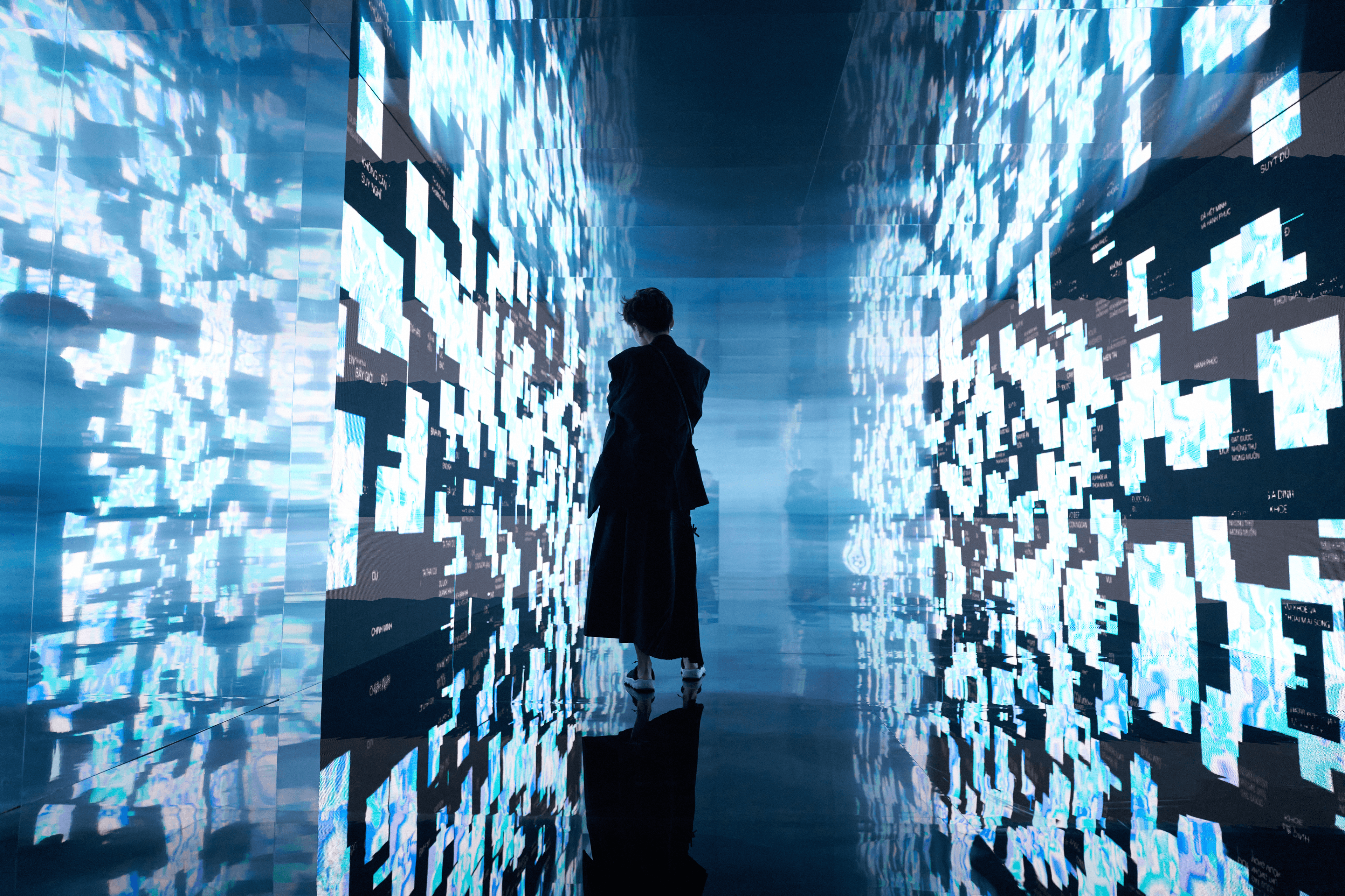 A visitor observes the final installation, an immersive environment visualizing collective 'fulfillment' data from all participants